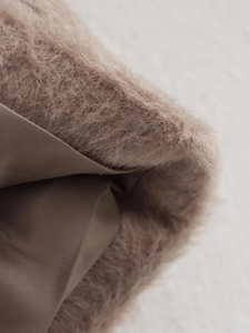 Detailed macro view of soft pink faux fur texture and durable brown twill lining