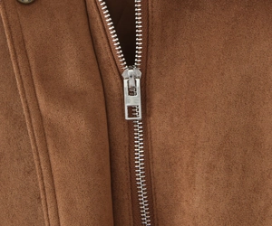 Detail of silver metal zipper and premium faux suede texture on casual jacket