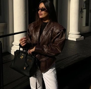 Detail der dunkelbraunen Kunstlederjacke mit breiten Schultern und Retro-Silhouette