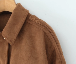 Detail of a brown suede jacket collar with visible stitching and premium matte texture