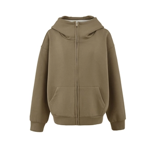 Détail d'un sweat à capuche zippé oversize kaki avec poches kangourou et poignets côtelés