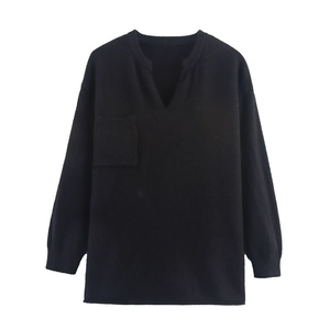 Detail eines schwarzen V-Ausschnitt Strickpullovers mit Brusttasche und Rippbündchen