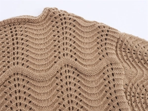 Detail of camel off-shoulder knitwear with fuzzy texture and hollow wave crochet pattern