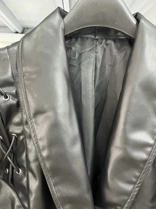 Detailansicht der schwarzen PU-Lederjacke mit seitlicher Schnürung und Metallösen