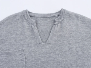 Detailaufnahme des grauen Strickpullovers mit V-Ausschnitt und gerippter Textur