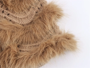 Detailed close-up of khaki knit fabric with plush faux fur trim on the sleeve edge