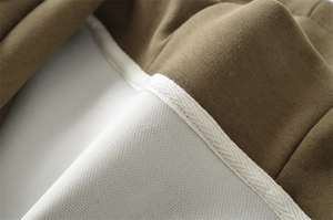 Détail de la doublure du sweat à capuche marron avec mesh alvéolé et ruban blanc