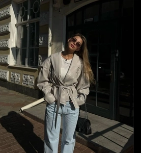 Streetstyle-Ansicht einer beige Kunstlederjacke mit Bindegürtel und großem Revers