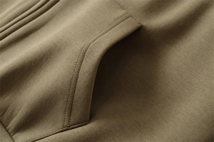 Gros plan détaillé des coutures de poche sur le sweat à capuche marron olive