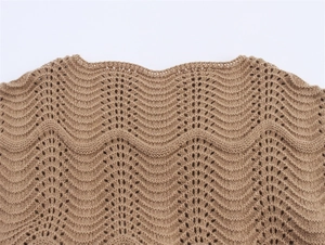 Detail view of brown knit dress showing off-shoulder scalloped hollow-out crochet pattern