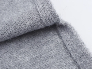 Makro-Detail der weichen grauen Strickstruktur mit hochwertigem Wollfinish