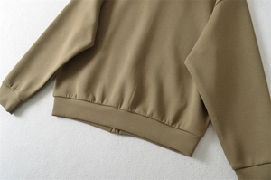Détails de l'ourlet côtelé et des poignets du sweat à capuche olive avec coutures soignées