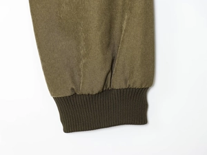 Detail der Bomberjacke in Olivgrün mit robustem Köperstoff und elastischen Rippbündchen