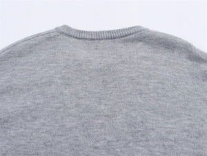Detailaufnahme von Ausschnitt und Schulternaht des grauen Strickpullovers