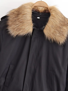 Detailed close-up of premium faux fur collar on black winter jacket with windproof fabric