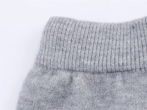 Detail der grauen Strickware mit vertikalen Rippbündchen und weicher Kaschmirtextur