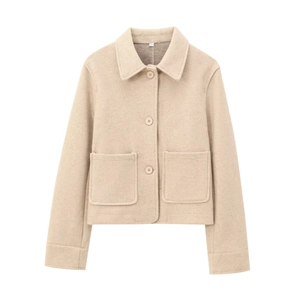 Detail shot of oatmeal wool jacket showing textured fabric, collar, and large square pockets
