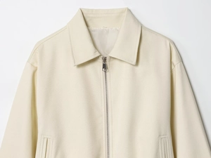 Detail of cream puff hem jacket with silver metal zipper and lapel collar texture