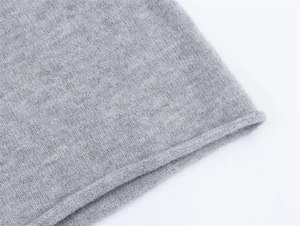 Detail der grauen V-Ausschnitt-Strickware mit feiner Textur und Rollsaum-Design