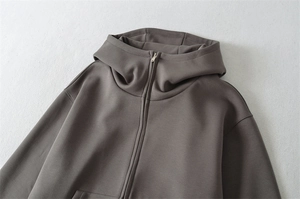 Détail du sweat à capuche à col montant avec fermeture éclair en métal argenté