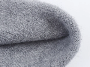Makroaufnahme der grauen Strickstruktur mit weichen Wollfasern und feinem Maschenbild