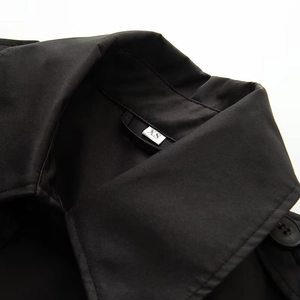 Detailed macro view of black windbreaker collar and stitching with an XS size label