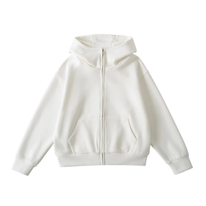 Détail d'un sweat à capuche blanc avec fermeture éclair métallique et poignets côtelés