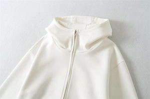 Détail du zip et de la capuche sur un sweat à capuche blanc cassé surdimensionné