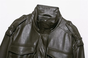 Detailed macro of olive green faux leather texture and metallic snap buttons on the jacket