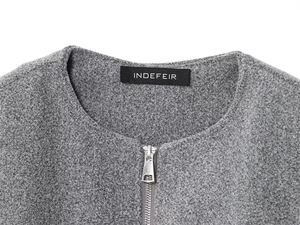 Close-up of a grey bomber jacket with a silver metal zipper and a minimalist round collar