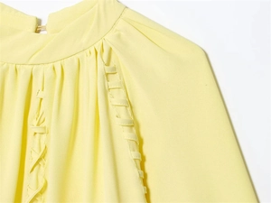 Detailansicht gelbe Bluse mit Faltenkragen und gewebten Details an der Schulter
