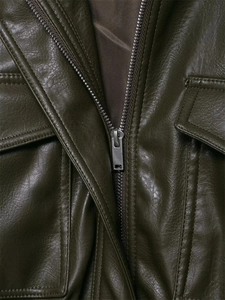 Detail view of dark green faux leather jacket with metal zipper and flap pockets