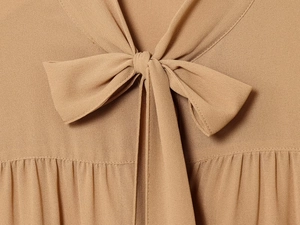 Detailaufnahme des khakifarbenen Chiffonhemd-Kragens mit Schleife und eleganten Falten