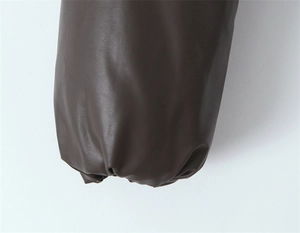 Detailed close-up of dark brown vintage PU leather jacket sleeve with elastic cuff design