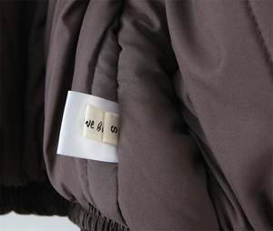 Detail view of the brown jacket's smooth inner lining with brand and size S tags