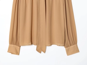 Detailansicht der camel-farbenen Schifonbluse mit Faltmanschetten und elegantem Band