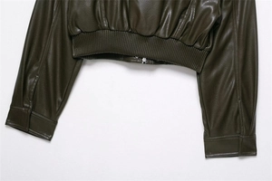 Detail of dark olive faux leather jacket featuring ribbed hem and fine leather texture