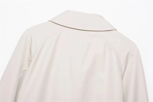 Detail of raglan sleeve stitching and premium beige trench coat fabric texture
