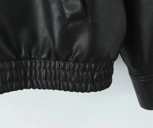 Dettaglio della giacca in pelle nera con orlo elastico e cuciture rinforzate delle tasche