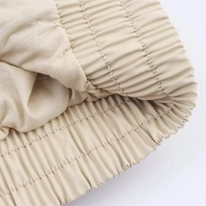 Macro detail showing elastic waist stitching and twill fabric texture on khaki jacket