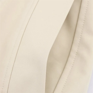 Close-up of khaki jacket fabric showing twill texture and precision stitching detail
