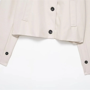 Short beige waterproof windbreaker jacket with stylish black buttons and lapel collar