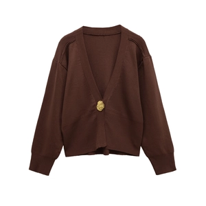 Detail of deep brown V-neck knit cardigan showing the gold irregular button and ribbed cuff