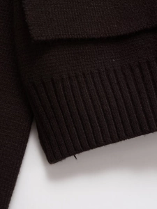 Détail de l'ourlet en maille côtelée marron foncé sur une veste à double boutonnage