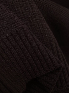 Macro de la texture en maille côtelée marron foncé d'un cardigan à double boutonnage