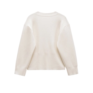 Detail view of cream-colored knit sweater featuring ribbed hem and cuff texture details