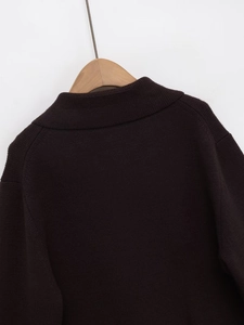 Détail de l'encolure côtelée et des coutures d'épaules tombantes sur ce gilet en maille