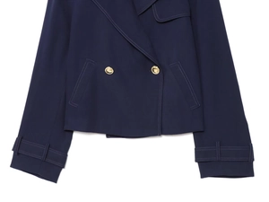 Detail view of navy short double-breasted jacket with white contrast stitching and gold buttons