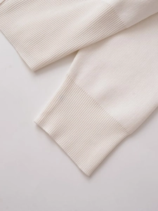 Close-up detail of cream white ribbed knit cuffs with premium fine stitching quality