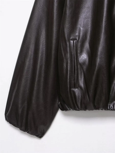 Detail of the side pocket and ribbed hem on the dark brown leather bomber jacket